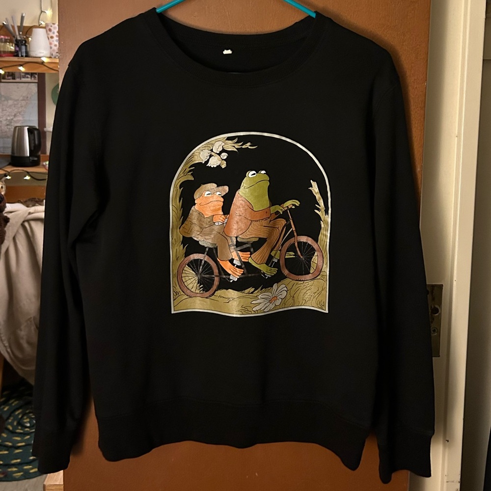 Cottagecore sweatshirt. Frog and Toad on a bicycle design on black sweatshirt.